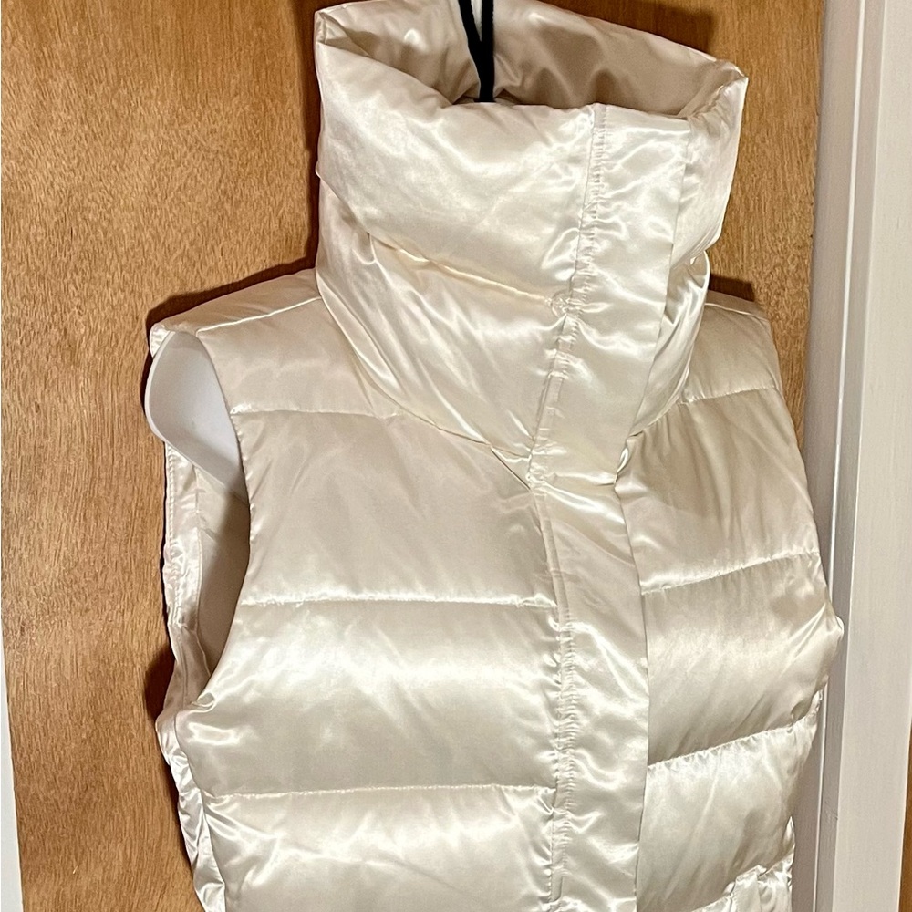 Ivory with a champagne sheen puffer vest.
Poly shell with down on interior.WOW!